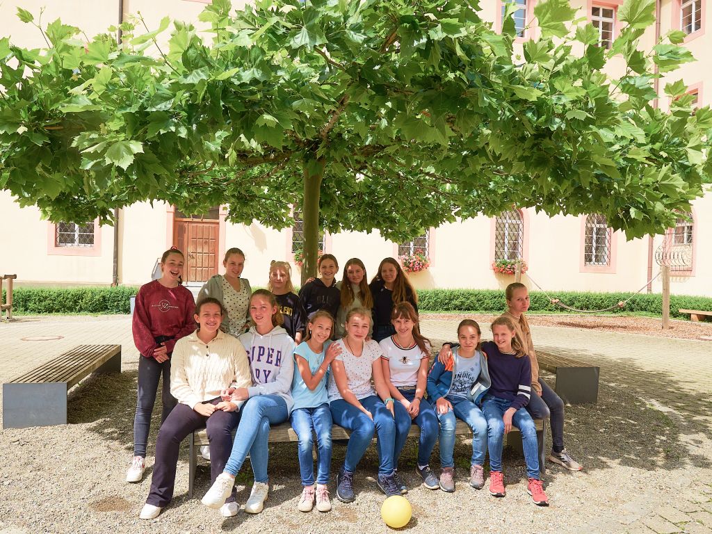 Gruppe fröhlicher Schülerinnen im Klosterhof